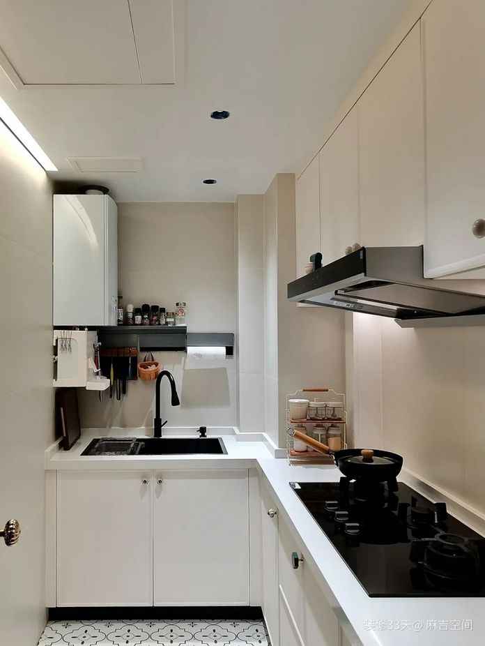 原始廚房較小且靠裡，選用乾淨的奶白色調，牆地磚選用 1200x600 的規格，縫隙更少更加整體，L型