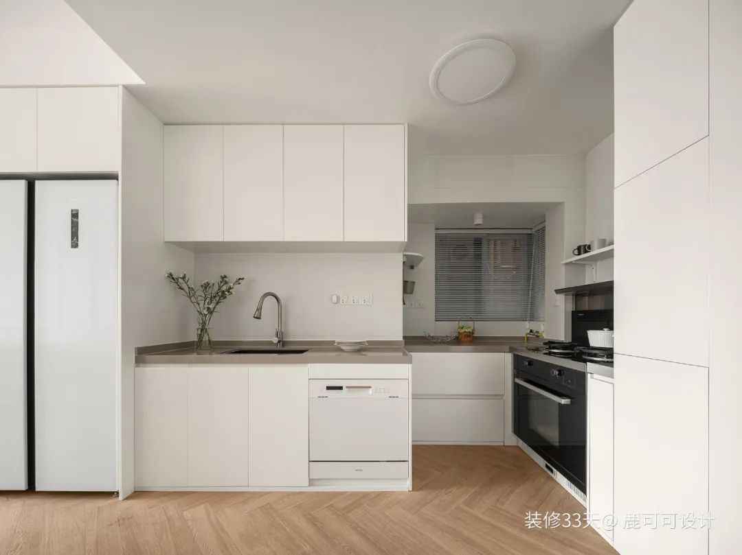 廚房，大面積留白的牆面通過光線反射使空間不開燈也比較明亮通透，動線是順暢的拿、洗、切、炒，啞光白色質