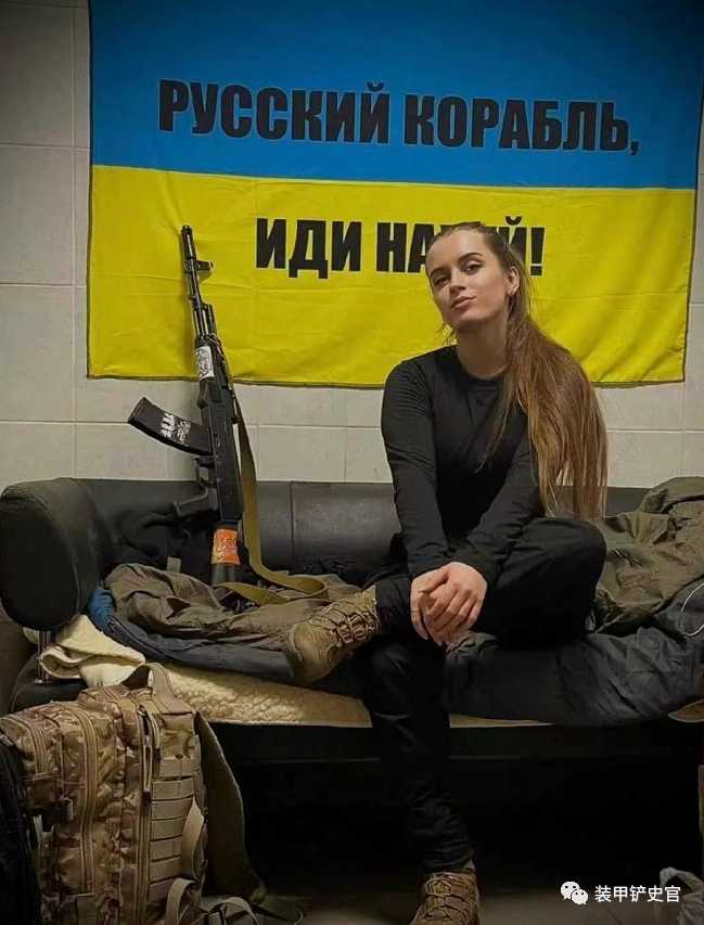 烏克蘭女兵與烏克蘭國旗國旗上半部分寫的是「俄羅斯軍艦」，下半部分是一句俄語國罵