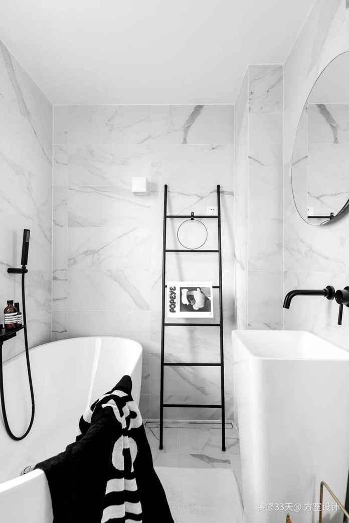 主衛，牆地面通鋪灰白色大理石紋瓷磚，搭配黑色五金，一體式臺盆，獨立浴缸，打造像酒店一樣充滿風情的衛生