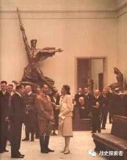 1940年的展覽期間，格迪女士（照片中身著白衣的女子）正向納粹黨副元首魯道夫·赫斯介紹展品背景處是阿