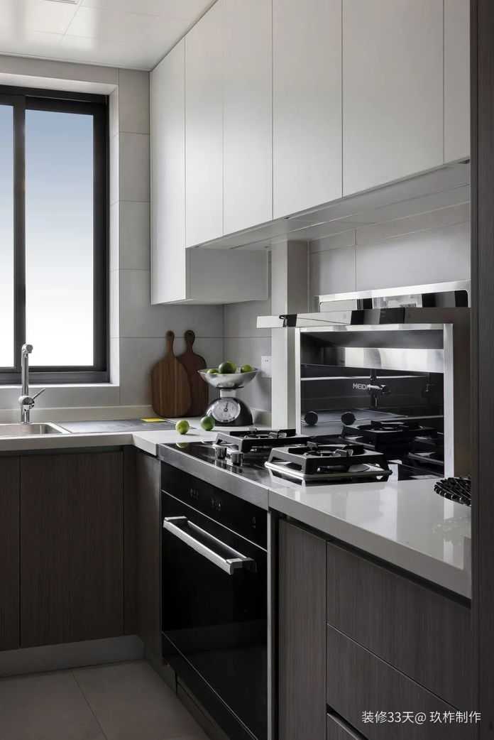 廚房，整體通鋪大理石瓷磚，搭配純白色吊櫃和深色櫥櫃，超大限度保留明度，形成空間色調的層次感