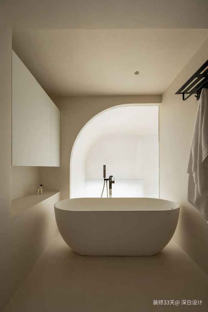 大浴缸擺放在弧形玻璃窗前，電子霧化玻璃保證通透性與私密性
